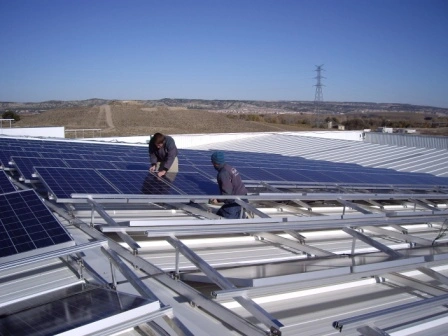 Workers installing solar panels on a rooftop.
